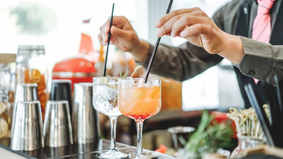 Licensed event bartender serving festive cocktails at a holiday party